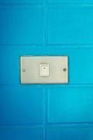 viejo interruptor blanco en la pared azul foto