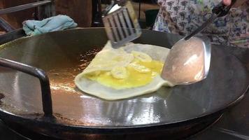 la signora sta cucinando un dolce roti con uova e banana - concetto di preparazione di cibo per dessert asiatico video
