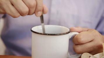 Man stir hot coffee cup in a hotel - people take a breakfast in hotel concept video