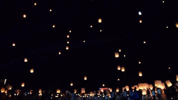 Soft focus of crowded people enjoy floating lanterns activity during Loy Krathong Festival in Chiang Mai - activity of local favorite tourist festival of Northern Thailand region concept video