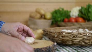 Lady cooks fresh champignon mushroom vegetable in the kitchen - people with vegetable cooking concept video