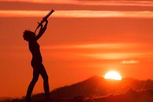 Saxophonist playing at sunset photo