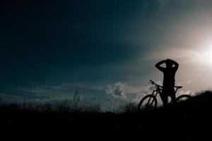ciclista con ebike descansa y mira el paisaje foto