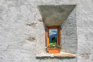 Window typical of the Swiss Alps, where the mountains are reflec photo