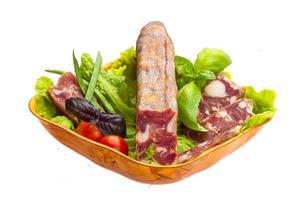 Ripe salami with salad, basil, onion and tomato photo