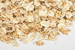 Heap of dry rolled oats isolated on white background photo