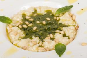 photo of delicious risotto dish with herbs and cedar nut on white background