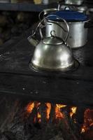 Stainless steel kettle on a wood stove. photo