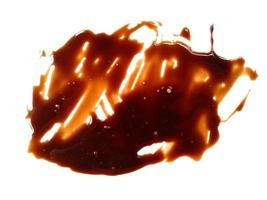 Spilled soy sauce sauce puddle isolated on white background. Texture of spilled soy sauce. Soy sauce on white background photo