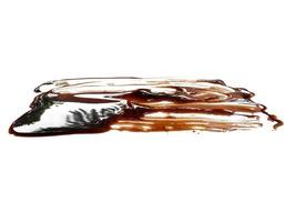 Soy sauce on white background. Spilled soy sauce sauce puddle isolated on white background. Texture of spilled soy sauce photo