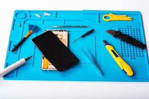 Flat lay image of dismantling the broken smart phone for preparing to repair or replace some components, Top view photo