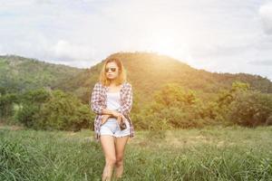 vintage de fotografía de mujeres hermosas mano de pie sosteniendo cámara retro con amanecer, estilo suave de ensueño foto