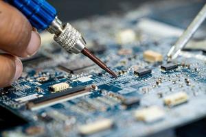 Technician repairing inside of mobile phone by soldering iron. Integrated Circuit. the concept of data, hardware, technology. photo