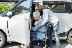 Asian senior or elderly old lady woman patient sitting on wheelchair prepare get to her car, healthy strong medical concept. photo