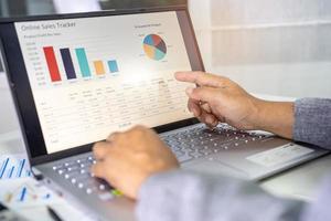 Asian accountant working and analyzing financial reports project accounting with chart graph in modern office, finance and business concept. photo