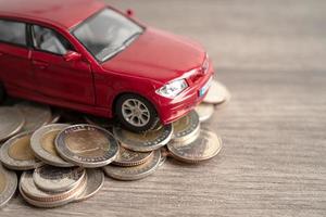 Car on stack of coins. Car loan, Finance, saving money, insurance and leasing time concepts. photo