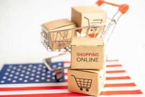 Box with shopping online cart logo and USA America flag, Import Export Shopping online or commerce finance delivery service store product shipping, trade, supplier concept. photo