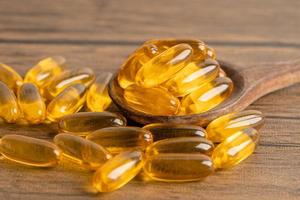 Fish oil Omega 3 capsules vitamin with EPA and DHA isolated on wooden background. photo