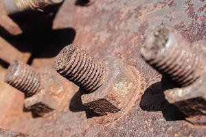 Oxidized old rusty bolts and nuts on the tower frame. photo