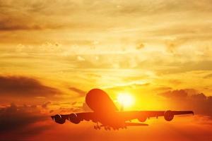 Airplane taking off at sunset. Silhouette of a flying passenger or cargo aircraft, airline photo