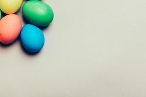 Four colored eggs in a corner on creamy background photo