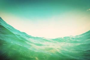 Water wave in the ocean. Underwater and blue sky. Vintage photo