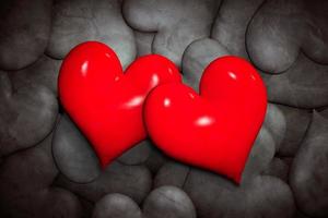 encontrar el concepto de amor. dos corazones rojos entre muchos en blanco y negro. foto