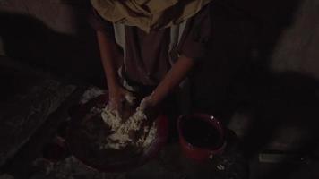 adulto mistura e amassa a massa para fazer pão, a câmera se afasta para ver a vista da mesa e do interior video