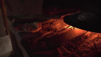 casserole du four à pain à feu ouvert à l'homme roulant la pâte sur une surface farinée