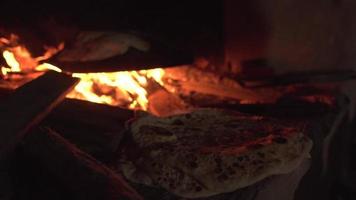 Brotbacken im Steinofen über Feuer bräunt und wird servierfertig herausgenommen video