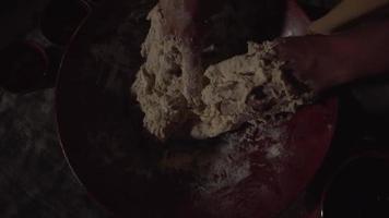 vue aérienne des mains mélangeant la pâte humide dans un grand bol rouge video