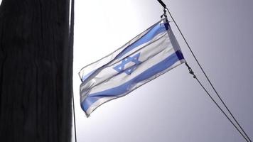 bandera de israel ondea en el viento iluminada por el sol con destello de lente video