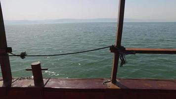 Der Blick vom Schiffsdeck, eingerahmt von einer Reling, schiebt sich dann nach vorne, um die volle Weite des Sees Genezareth zu enthüllen video