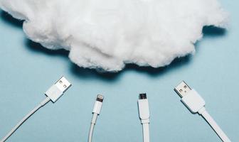 Four white wires laying under a white cotton cloud. photo