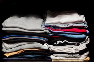 PIles of various clothes from laundry in a wardrobe photo