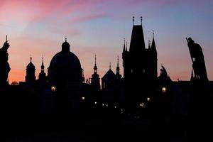 Charles Bridge at sunrise, Prague, Czech Republic. Dramatic statues and medieval towers. photo