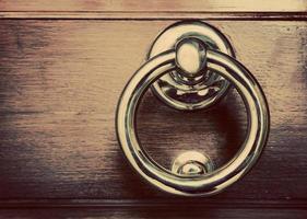 Antique golden door knocker on wooden door. Vintage background photo