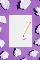 Blank white page and pen laying on violet background photo