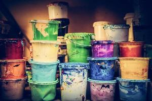 Buckets of liquid paint standing in a workshop. photo