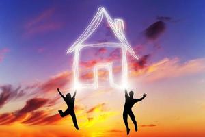 A couple jump and make a house symbol of light. New home, mortgage. photo
