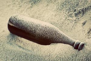 Old frozen bottle lost on the beach. photo