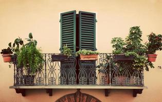 balcón romántico retro. ventana con persiana verde. vintage italy, pienza en toscana. foto