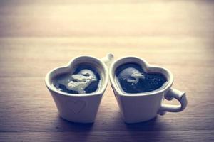 café negro, espresso en dos tazas en forma de corazón foto