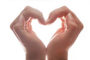 Hands make a heart shape on white background, backlight. Love photo