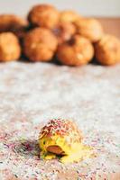 Yellow doughnut decorated with sugar strands photo