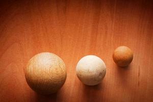 tres bolas de madera sobre una tabla de madera. foto