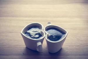 café negro, espresso en dos tazas en forma de corazón foto