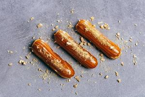 Three caramel eclairs on a grey counter photo