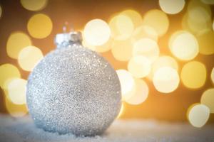 Christmas glass ball in snow. Glitter lights background photo