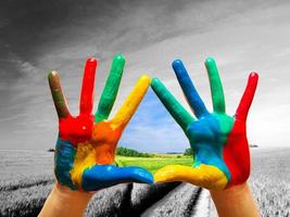 manos pintadas de colores que muestran el camino a una vida feliz y colorida foto